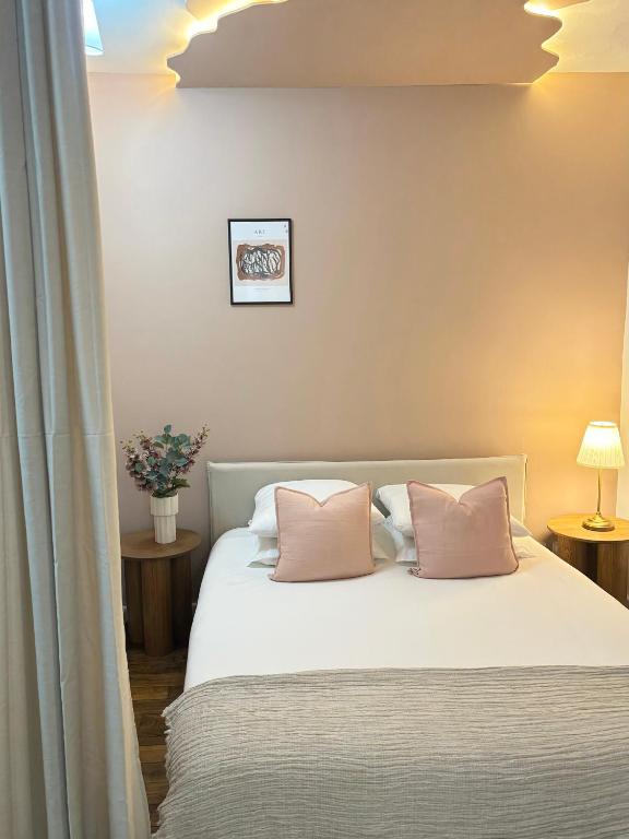 - une chambre avec un lit et 2 oreillers roses dans l'établissement La Suite Saint-Sébastien, à Paris