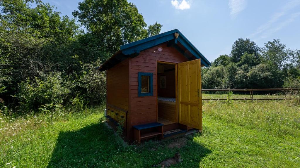 mały drewniany domek na trawie w obiekcie Apidomek w mieście Hostim