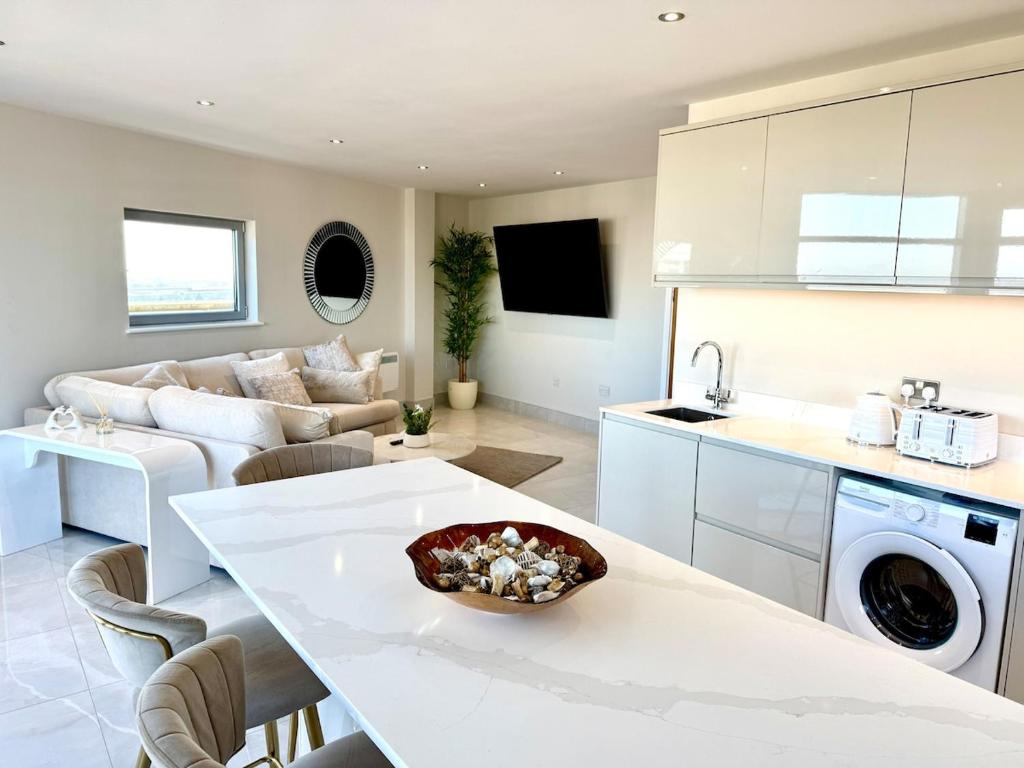 a kitchen and living room with a table and a couch at Cardiff Skyline Penthouse Apartment Free Parking Sleeps 8 in Cardiff