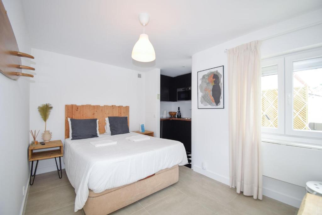 una camera da letto bianca con un letto e una finestra di Cozy Studio near the beach a Cascais