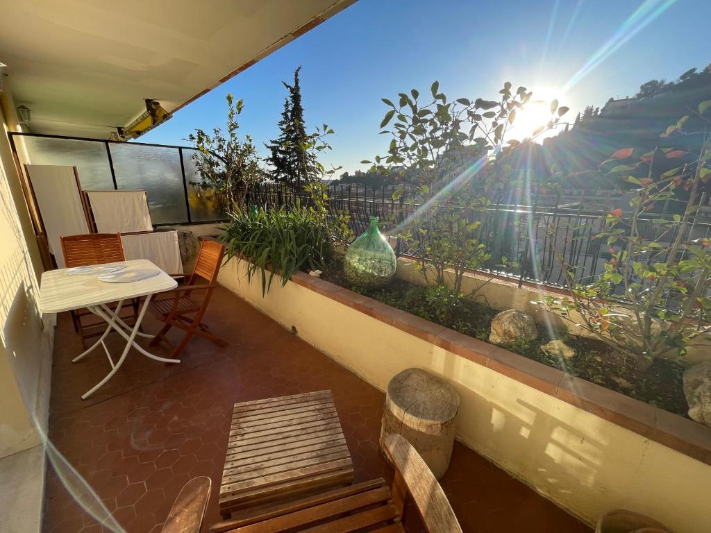 un balcon avec une table et des chaises et une vue dans l'établissement Lovely Sunny Studio, à Menton
