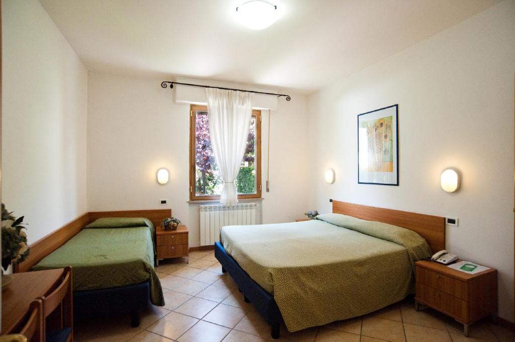 Hotel La Toscana في أريتسو: غرفة فندقية بسريرين ونافذة