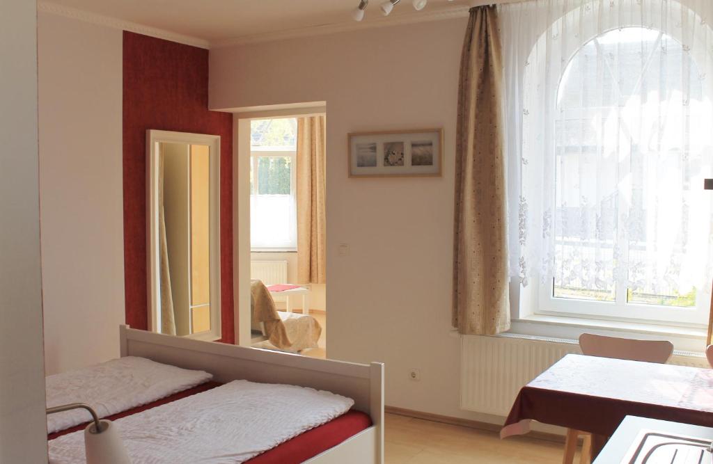 a bedroom with a mirror and a bed and a table at Villa Mignon - Apartment Rot in Ostseebad Koserow