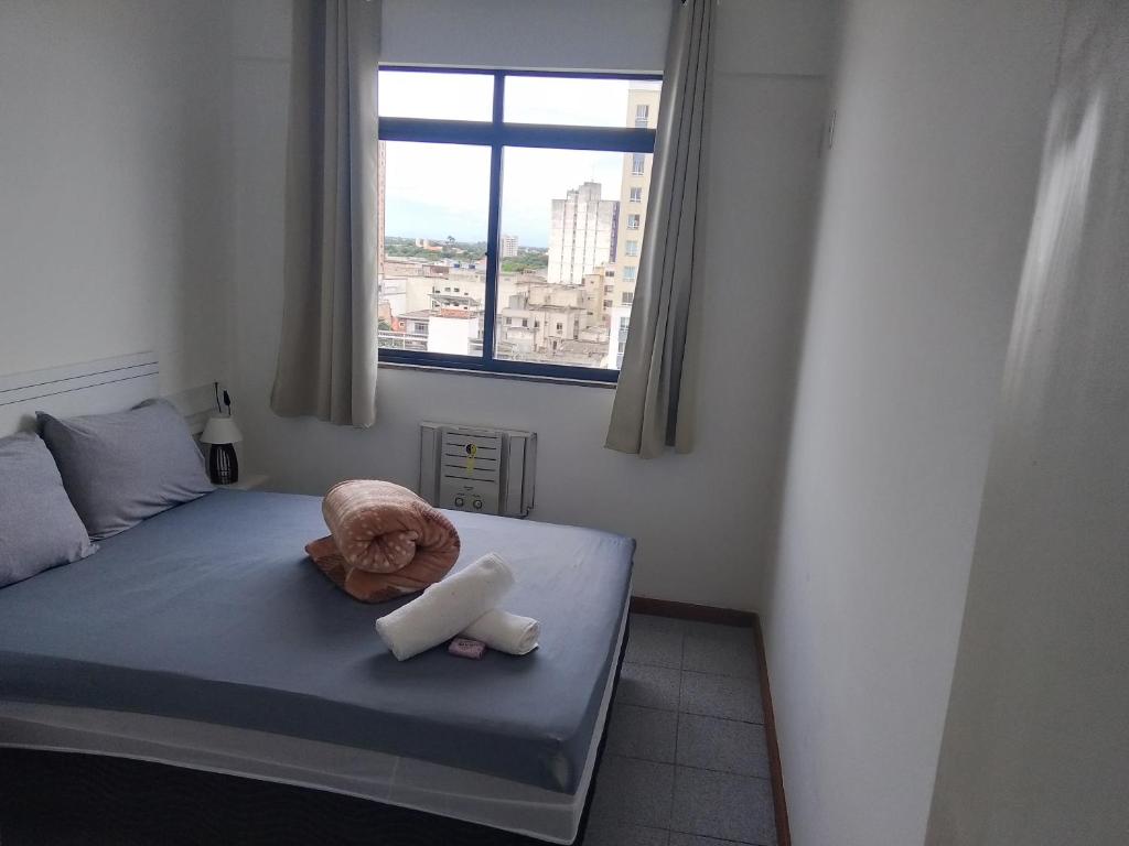 a bedroom with a bed with a stuffed animal on it at flat no centro da Cidade in Campos dos Goytacazes