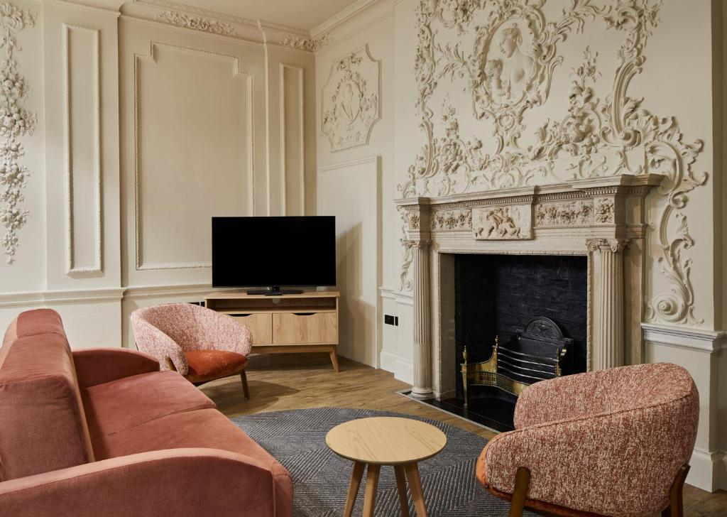a living room with a couch and a fireplace at master Cannon in London