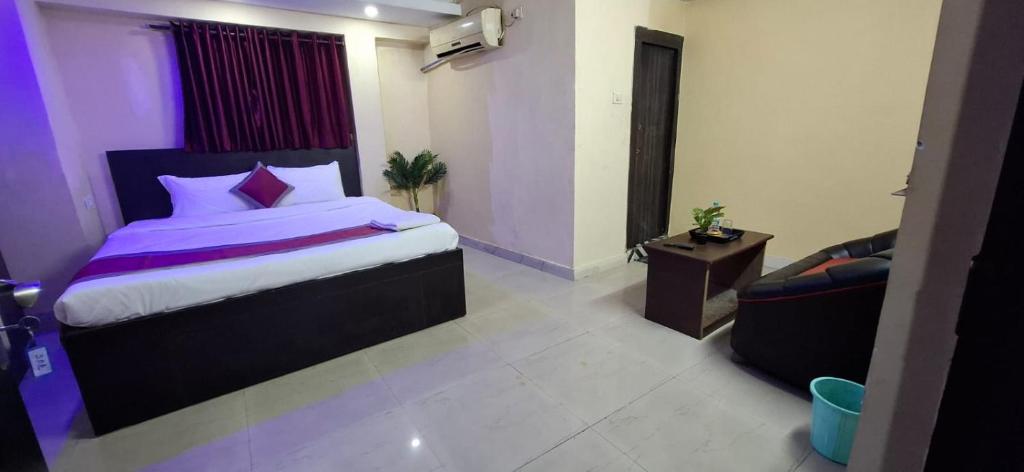 a bedroom with a king sized bed and a couch at The Hygge Guest House in Kolkata