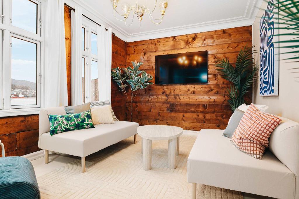 a living room with a couch and a tv on a wall at Dinbnb Home - History meets Modern I 3-Story Bergen House in Bergen