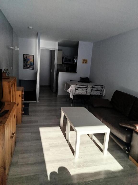 un salon avec un canapé et une table dans l'établissement Résidence Le Tourmalet - maeva Home - Appartement 2 pièces 6 personnes - Confort MAE-5141, à La Mongie