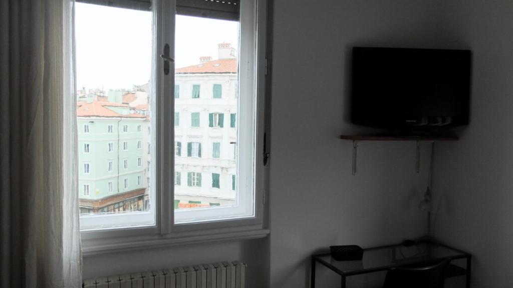Pokój z telewizorem i dużym oknem w obiekcie B&B Piazza Goldoni w Trieście