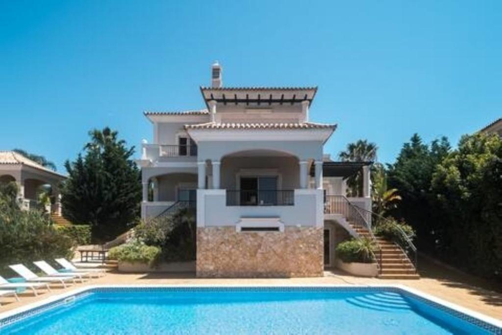 a large house with a swimming pool in front of it at Crest 5 - 8 Pax Golf & Beach Swimming pool in Almancil