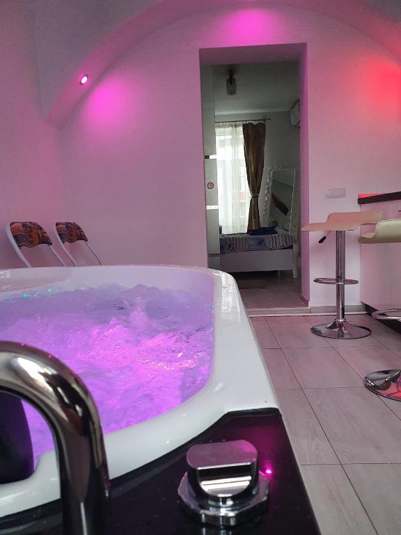 a bathroom with a tub filled with purple water at White House & Jacuzzi in Sibiu