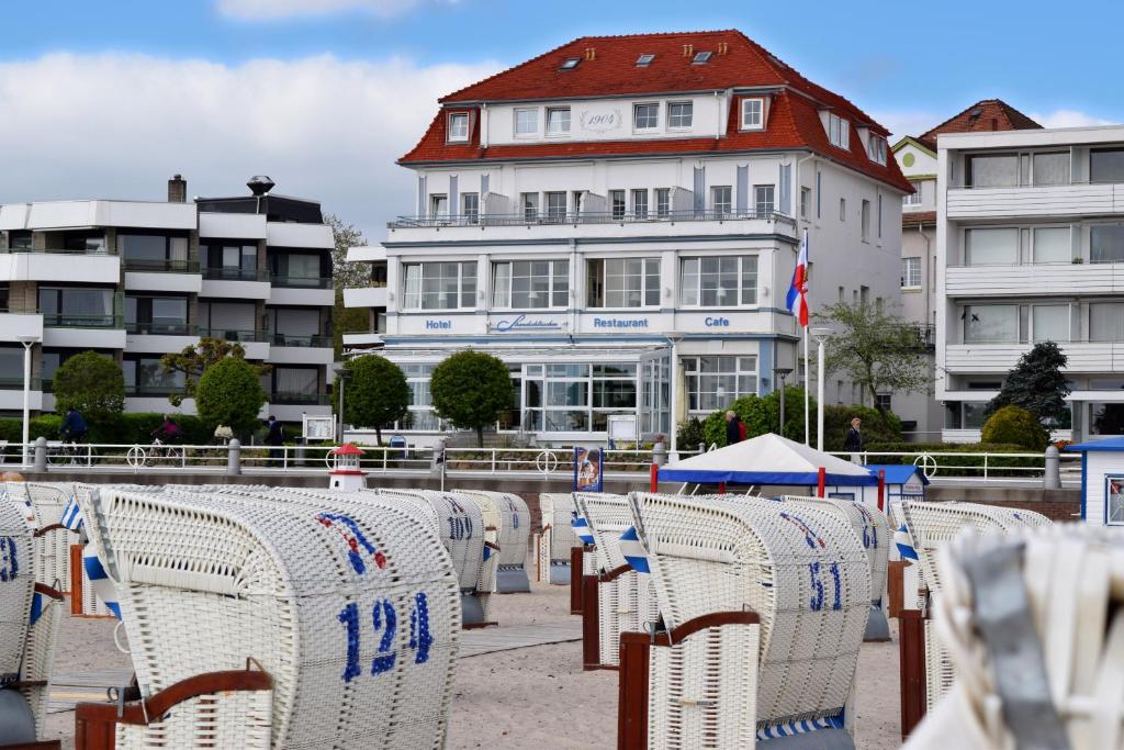 eine Reihe von Stühlen vor einem Gebäude in der Unterkunft Hotel Strandschlösschen in Travemünde