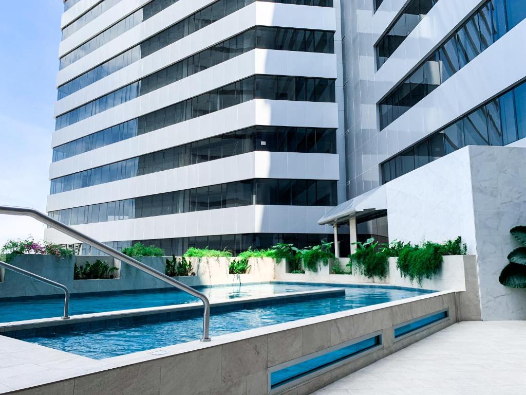 a swimming pool in front of a building at Vista a la ciudad, piscina, gym, cine, parking free in Mapasingue