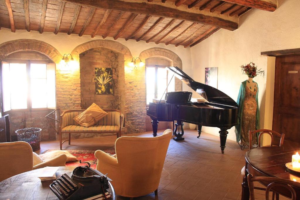 a living room with a piano and a couch at La Locanda del Loggiato in Bagno Vignoni