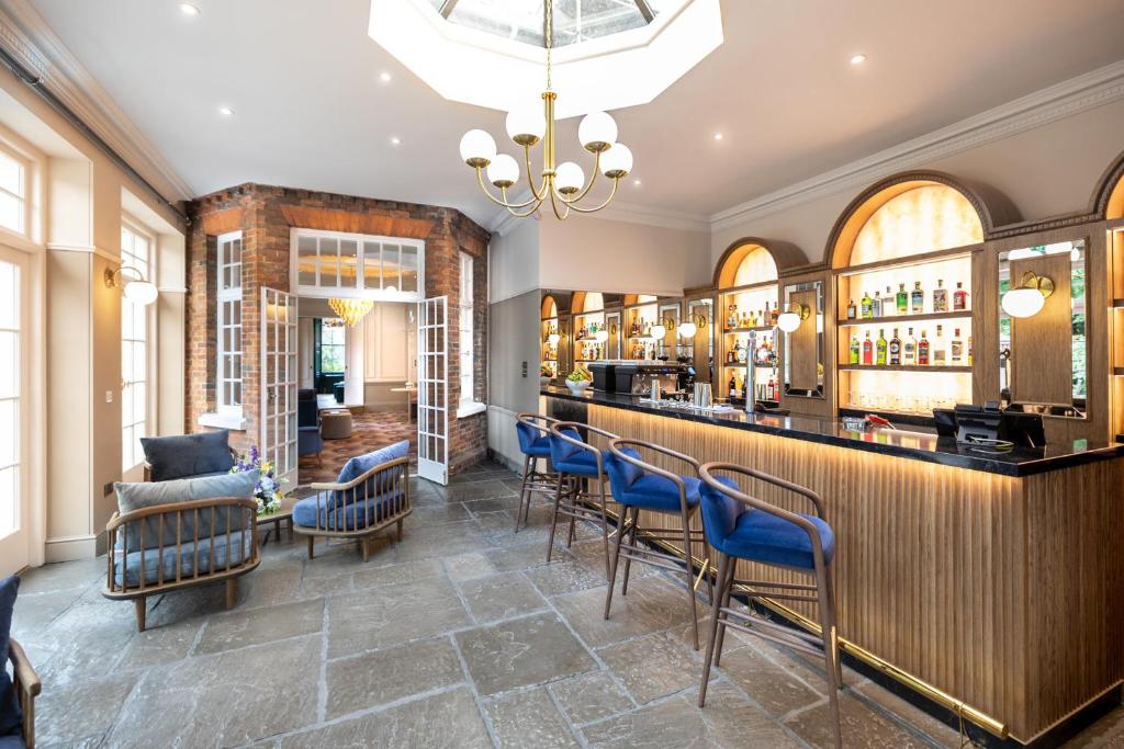 a restaurant with a bar with blue chairs at Milford Hall Salisbury in Salisbury