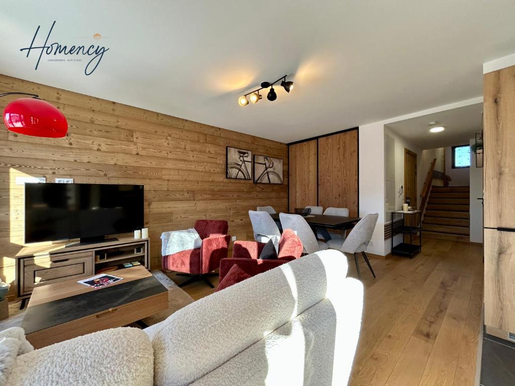 un salon avec un canapé, des chaises et une télévision dans l'établissement Homency - Résidence L'Expression B11, à L'Alpe-d'Huez