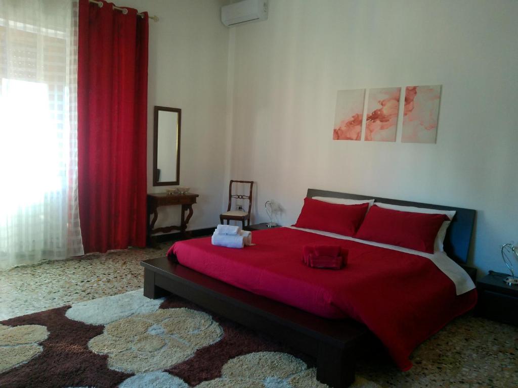 a bedroom with a large bed with red pillows at Cappuccini apartments superior in Oristano