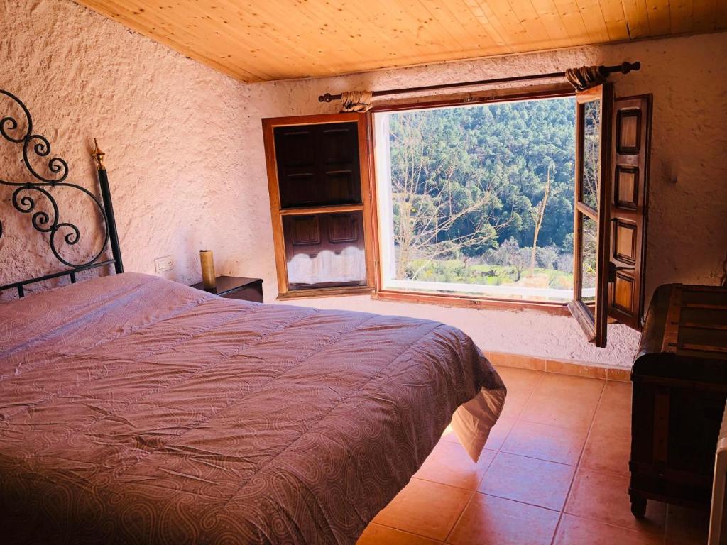 una camera da letto con un letto e una grande finestra di Vivienda turística LA CAPE a Segura de la Sierra