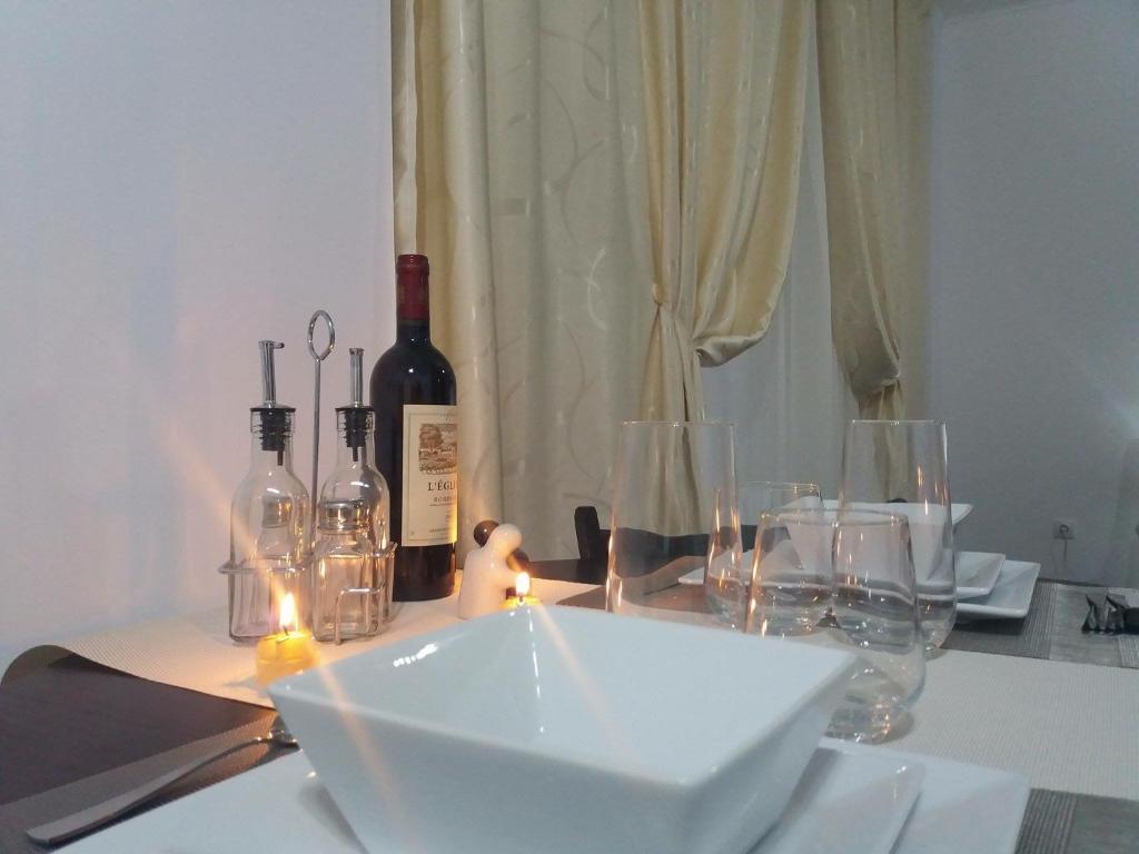 a table with wine bottles and glasses on it at Sophia Studio in Iaşi