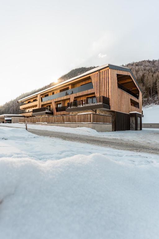 皮勒尔湖畔圣乌尔里希Jaggling Appartements的一座建筑物前有雪