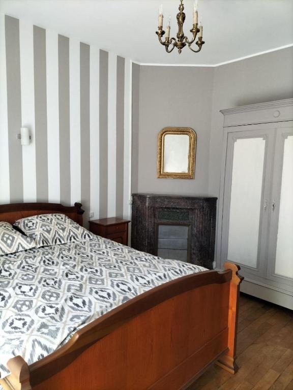 une chambre avec un lit et un miroir au mur dans l'établissement Au coeur d'un village creusois, à Néoux