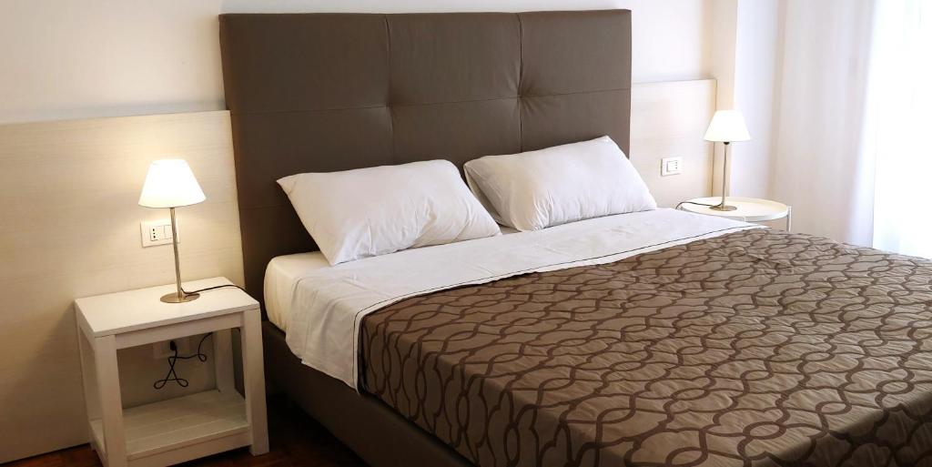 a bedroom with a large bed with two night stands at casa a schiera, a 150mt dal mare in Lido di Jesolo