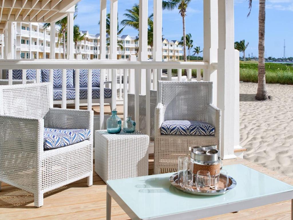 a porch with wicker chairs and a table at Isla Bella Beach Resort & Spa - Florida Keys in Marathon
