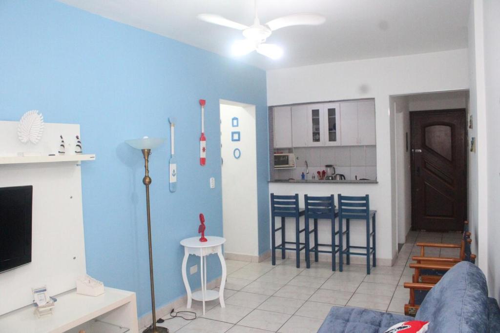 Il comprend un salon avec un mur bleu et une cuisine. dans l'établissement Apto Beiramar com piscina em Praia Grande, à Praia Grande