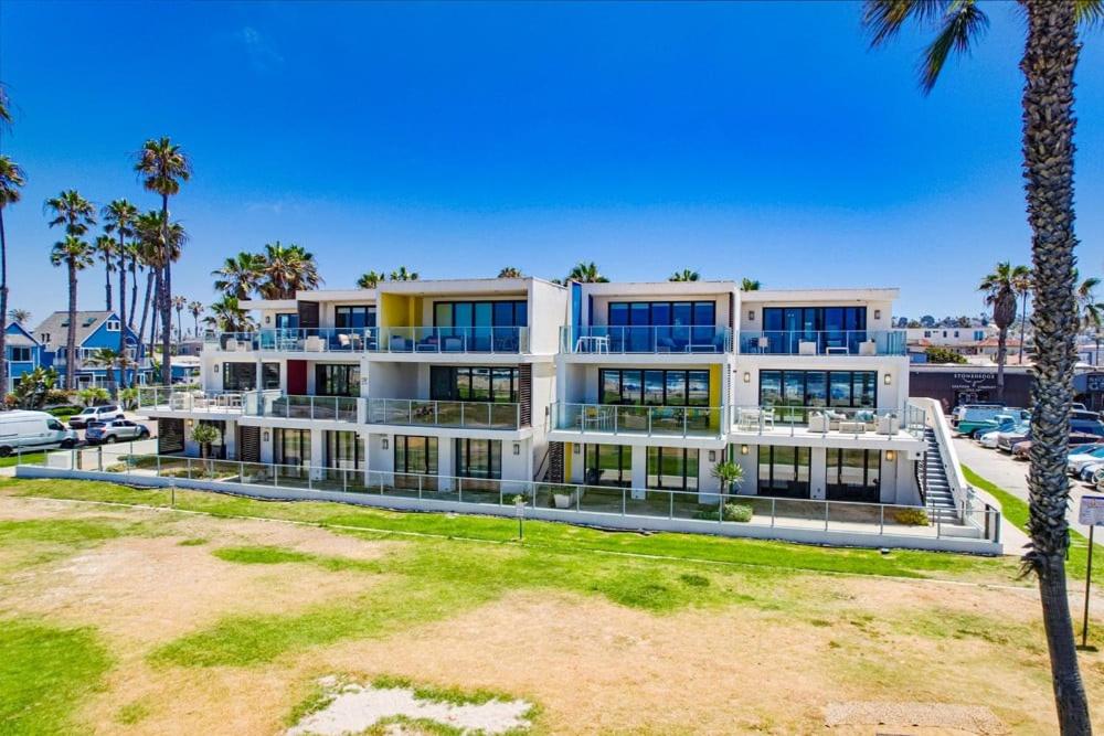 a large white building with palm trees and a parking lot at Ocean Park 08 in San Diego