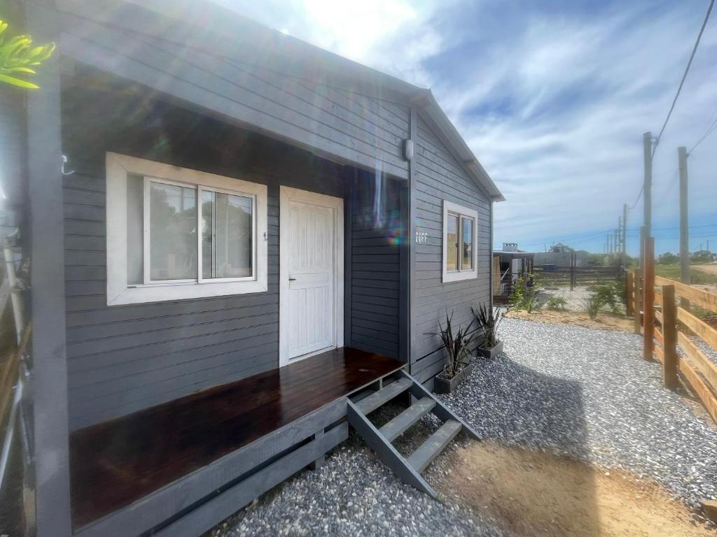 a gray house with a white door and windows at cabaña NFF in Punta Del Diablo
