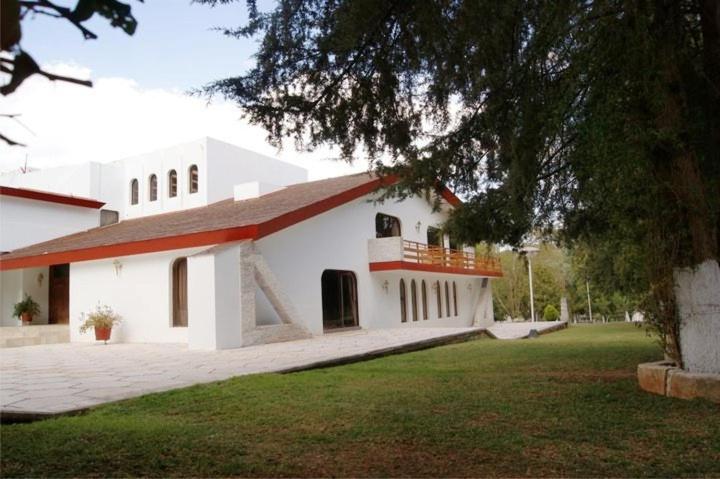 un gran edificio blanco con un árbol delante en Quintaesencia Hotel Boutique, en Huasca de Ocampo