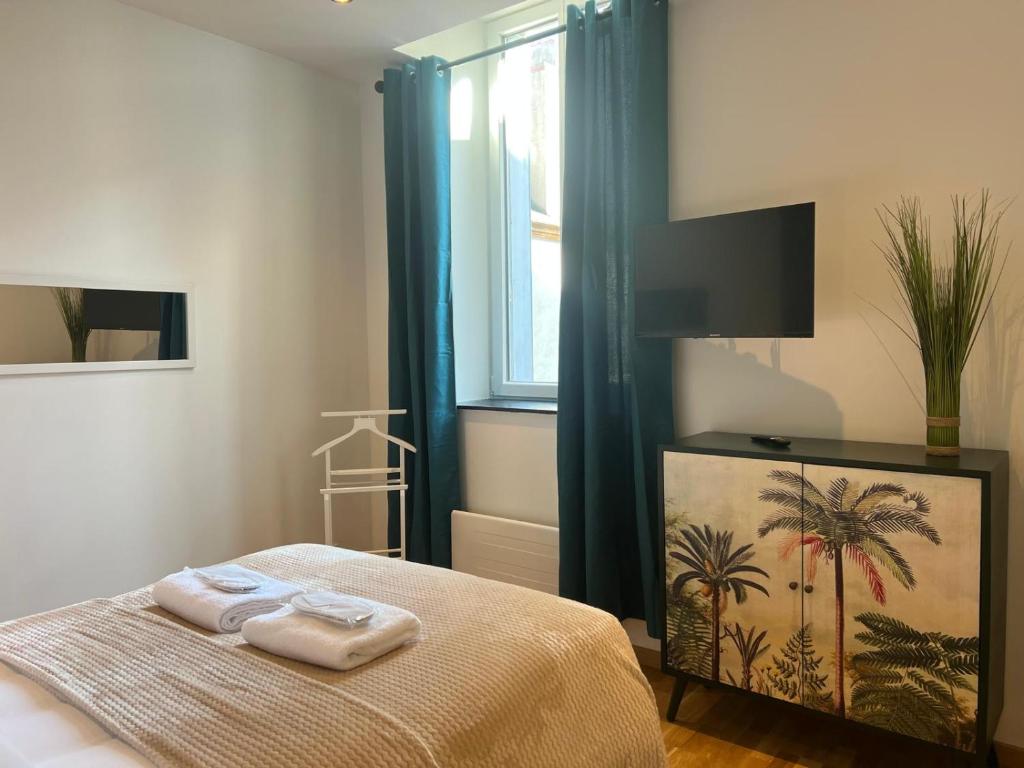 a bedroom with a bed with towels on it at L'Original - Villa Courtais - Hypercentre in Montluçon