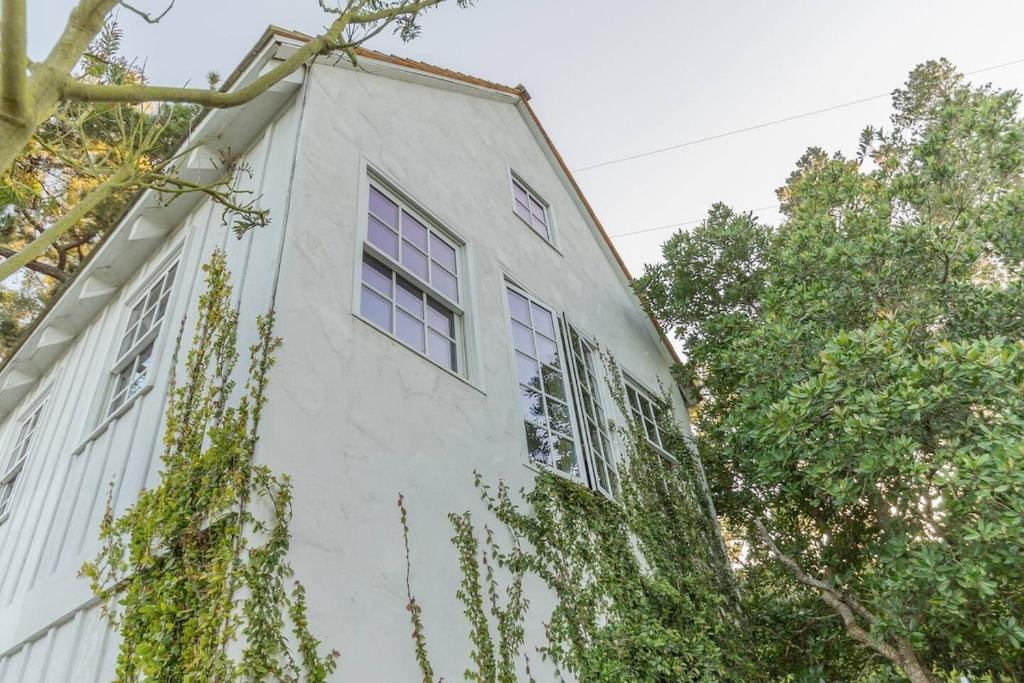 un bâtiment blanc avec des arbres devant dans l'établissement Romantic Carmel Cottage Ocean Country Views, à Carmel