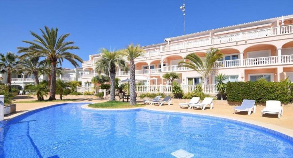 une grande piscine devant un immeuble dans l'établissement Boho chic Ibiza vibe appartment 4p, à Benissa