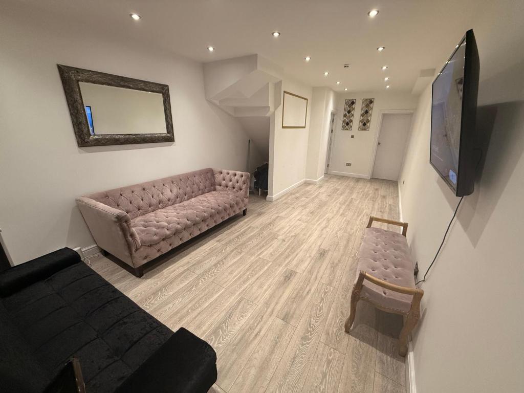 Una sala de estar con un sofá y un televisor de pantalla plana. en Luxe Guesthouse, en Stoke on Trent
