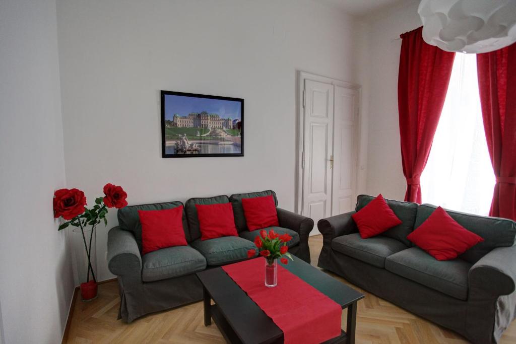 ウィーンにあるGasser Apartments - Altstadt City Centerのリビングルーム(ソファ2台、赤い枕付きのテーブル付)