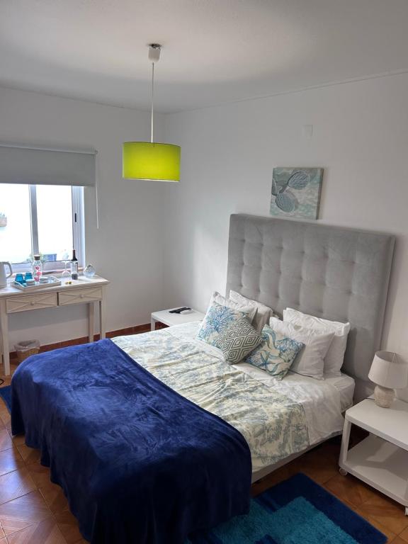 una camera da letto con un letto grande con una coperta blu di Vivenda Rosa Lagos a Lagos