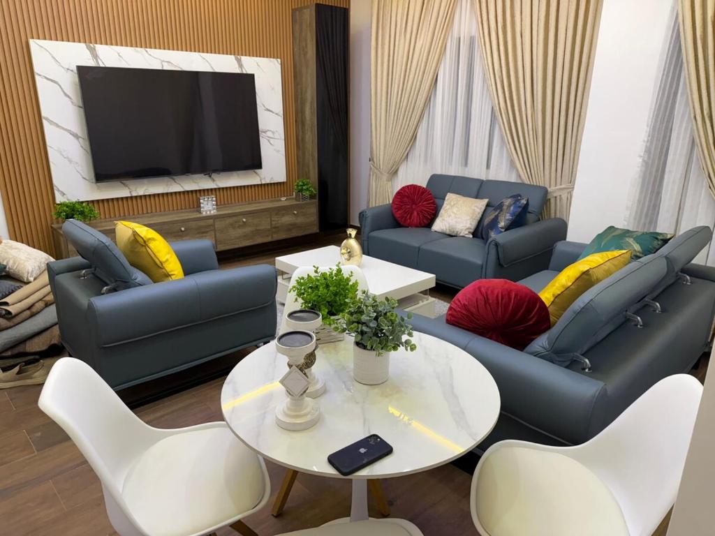 a living room with couches and a table and a tv at Luxury One bedroom Apartment R1 in Lomé