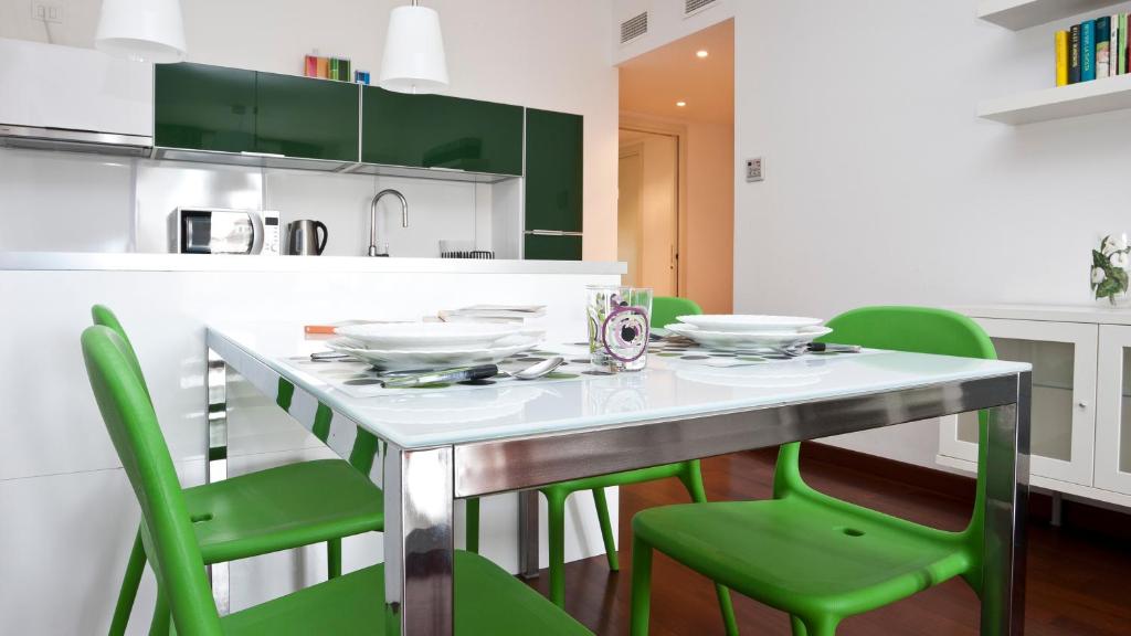 a kitchen with a table and green chairs at Italianway-Naviglio Pavese in Milan