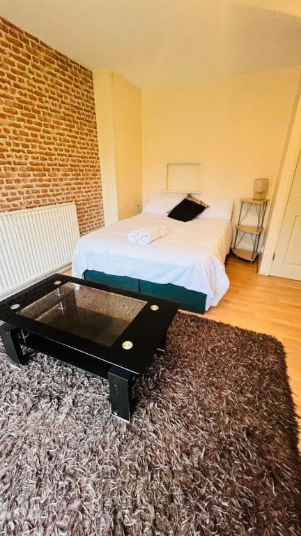 a bedroom with a bed and a table on a rug at Convenient Retreat Rooms in Reading