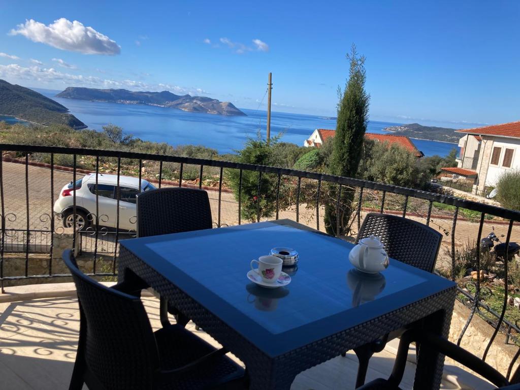 einen blauen Tisch auf einem Balkon mit Blick auf das Wasser in der Unterkunft Kaş Güzey apart 3+1 Doğa ve deniz manzaralı in Kaş