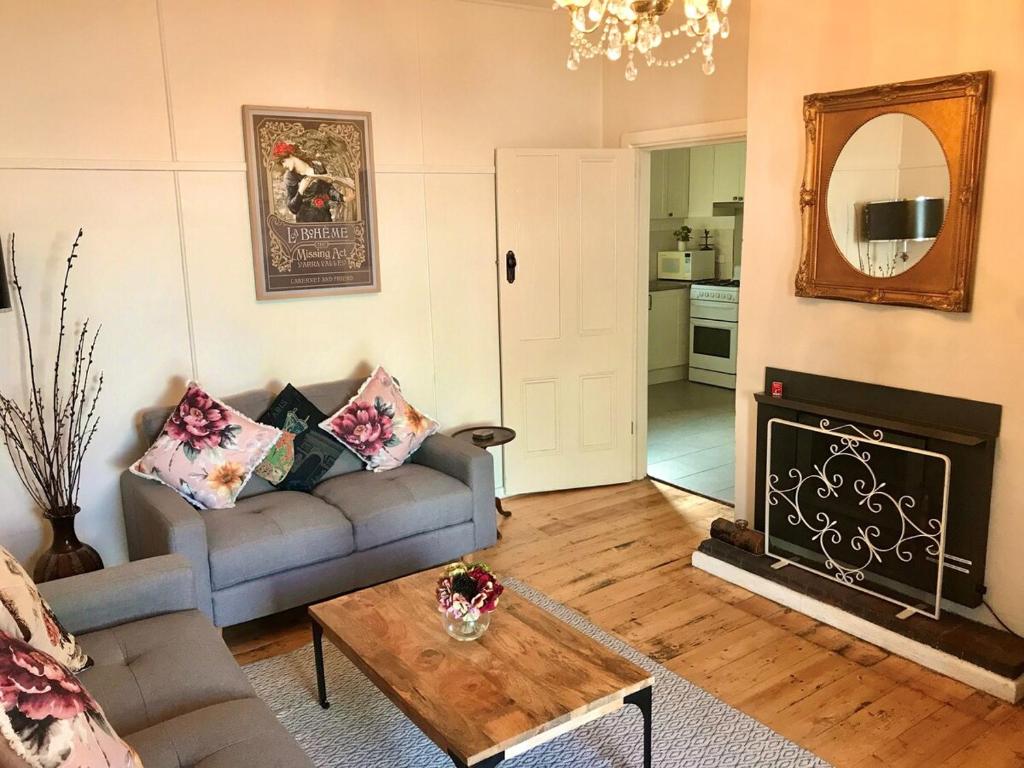 a living room with a couch and a fireplace at Courtyard Cottage Healesville, close to everything in Healesville