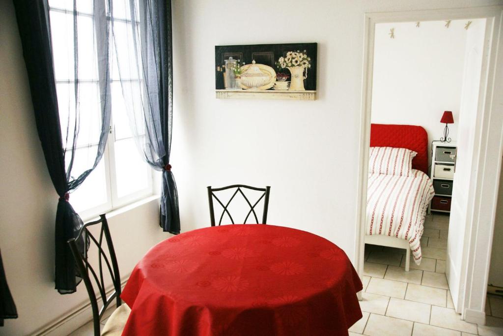 una mesa roja en una habitación con 1 dormitorio en Gite Escale en Ville, en Louviers