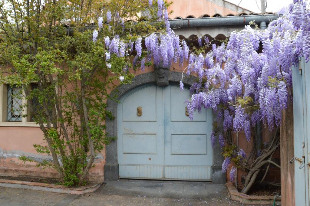 a wreath of purple flowers hanging over a door at Relais de Charme - B&B Short Lets La Casa di Francesca in Sant’Agata Li Battiati 
