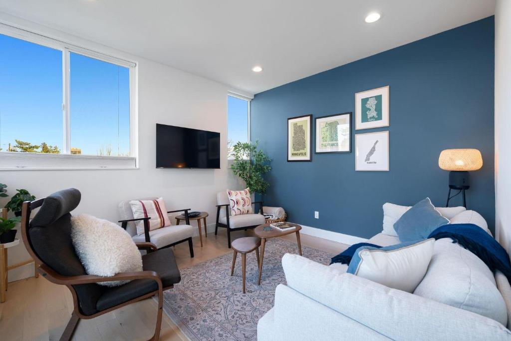 a living room with blue walls and a couch and chairs at Wallingford Getaway in Seattle