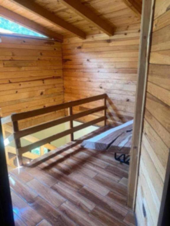 a room with a bed in a wooden cabin at Cabaña Paty in Mazamitla