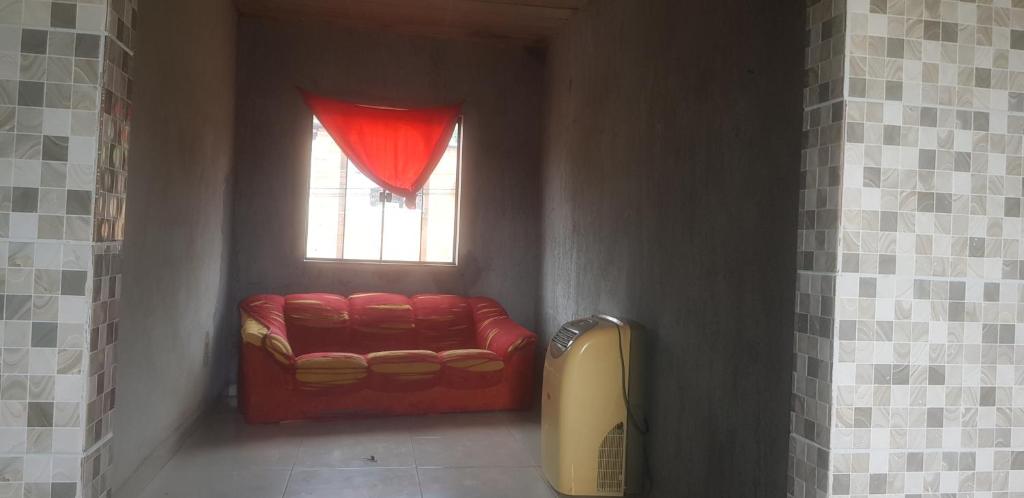 a red couch in a room with a window at Aconchego de Matias in Matias Barbosa