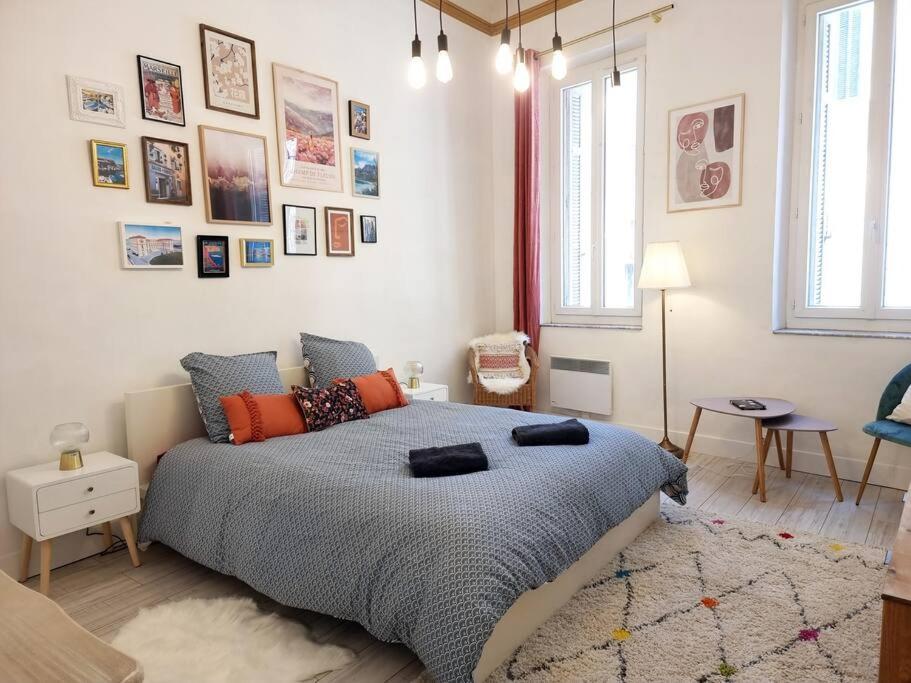 - une chambre avec un grand lit et des photos sur le mur dans l'établissement Appartement resplendissant entre la Plaine et le Cours Julien et proche du centre-ville, à Marseille
