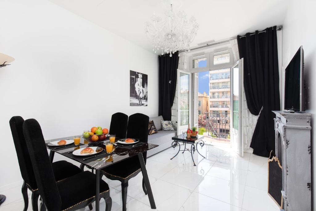 une salle à manger avec une table et des chaises noires dans l'établissement Pelige 5 YourHostHelper, à Cannes