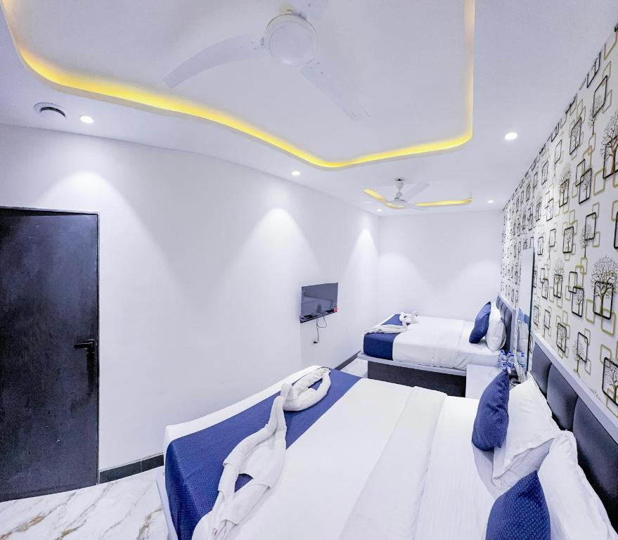 孟买Hotel Flora Inn的一间酒店客房,设有两张床和电视